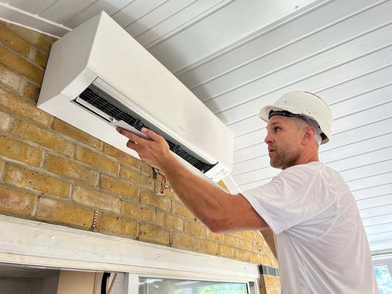 A technician installs an air conditioner 