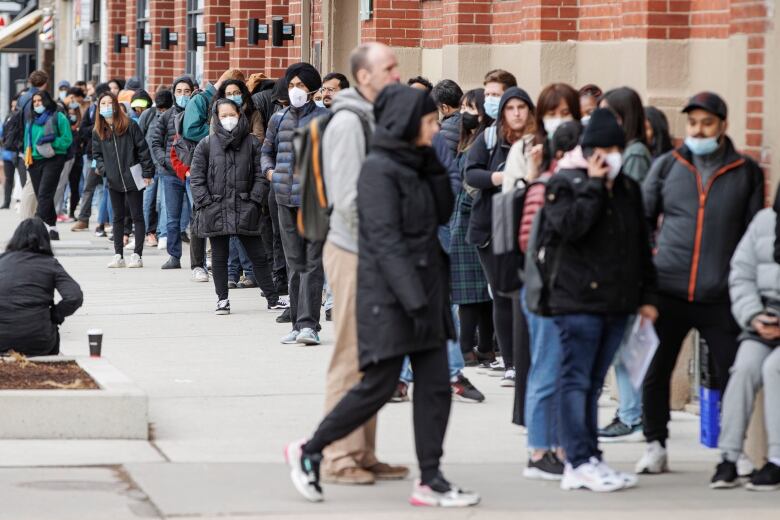 People line up outside a Service Canada office in Toronto on Apr. 26, 2022. Loosening travel restrictions have led to a rise in demand for passports.