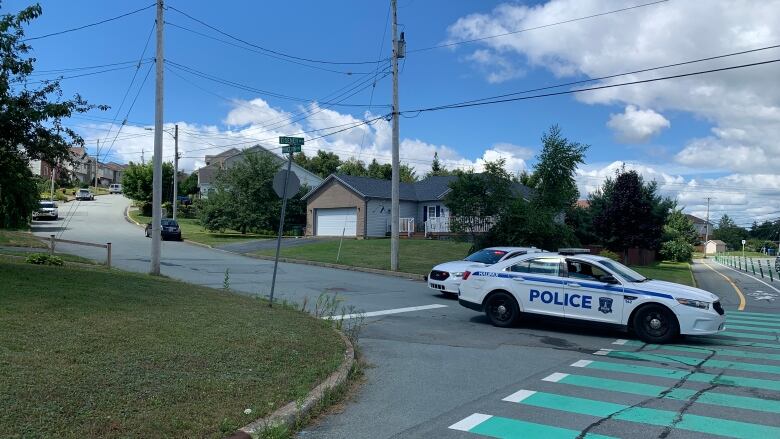 two police cruisers block a residential lane