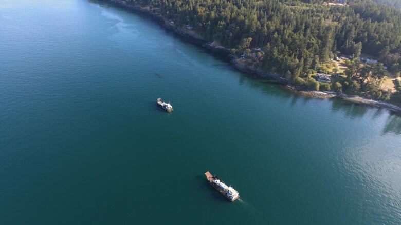 Response vessels with a vacuum trucks on board are shown off San Juan Island, Washington. The United States Coast Guard says commercial divers are assessing a sunken fishing boat that went down Saturday in waters on the U.S. side of Haro Strait and is leaking fuel not far from southern Vancouver Island. 