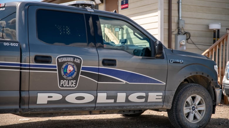 A silver pickup truck is emblazoned with the blue and white logo of Nishnawbe Aski Police