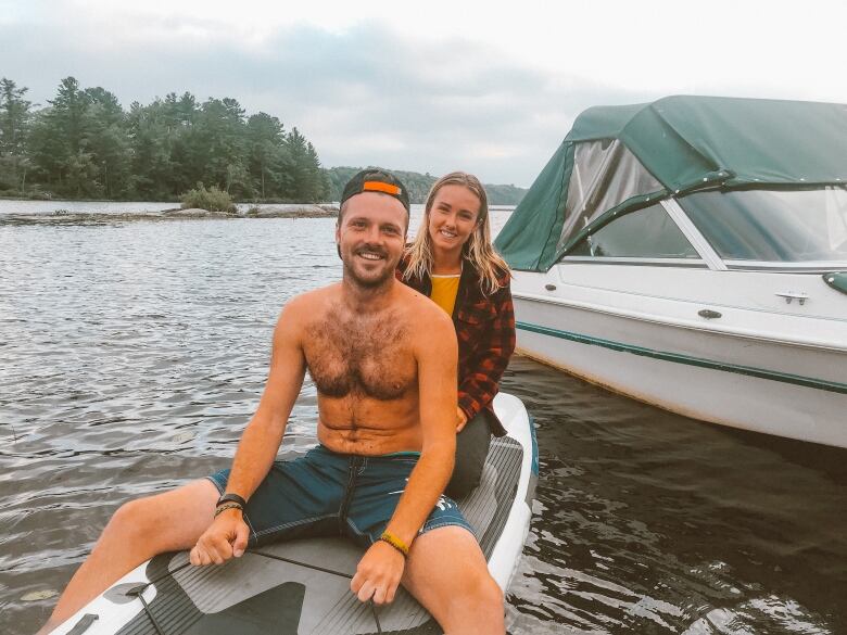 Chris and Michelle Owens smiling for the camera while on a paddleboard in the water.