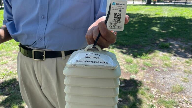 Man holding a white portable sensor