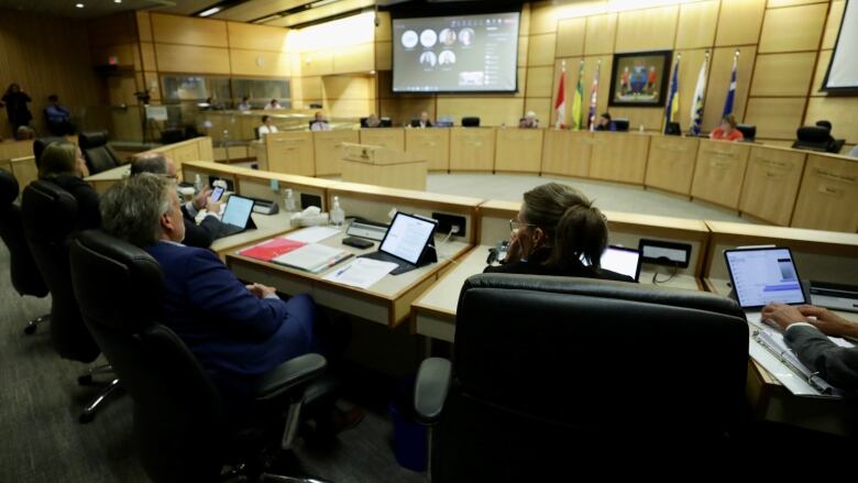 Members of City of Regina administration watch as city council holds a meeting at city hall on Aug. 17, 2022.