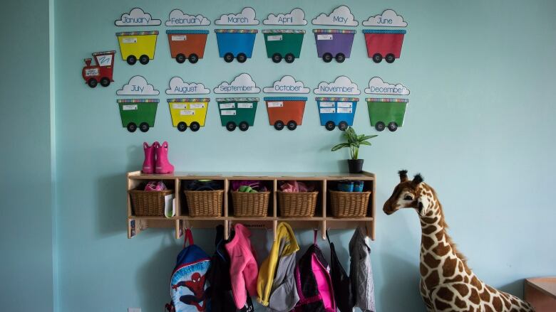 Jackets are hung up along the wall at a day care.