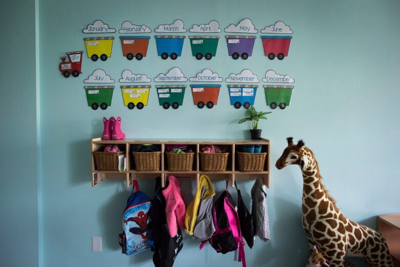 Jackets are hung up along the wall at a day care.