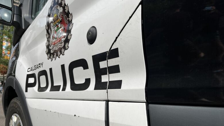 The side door of a black-and-white police cruiser.