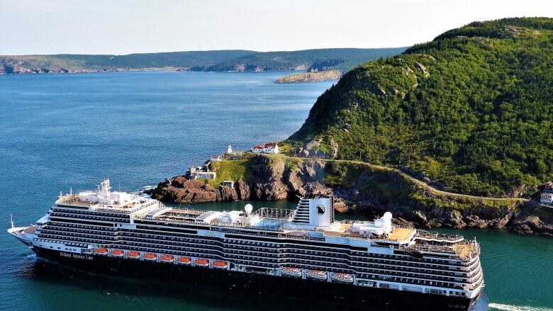 A large cruise ship sales away from land.