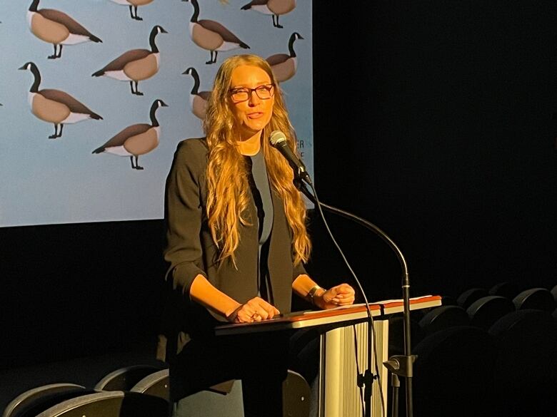 A woman speaking at a podium.