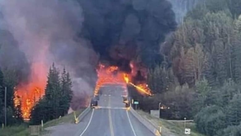 Fire on a bridge with a large plume of smoke reaching into the sky.