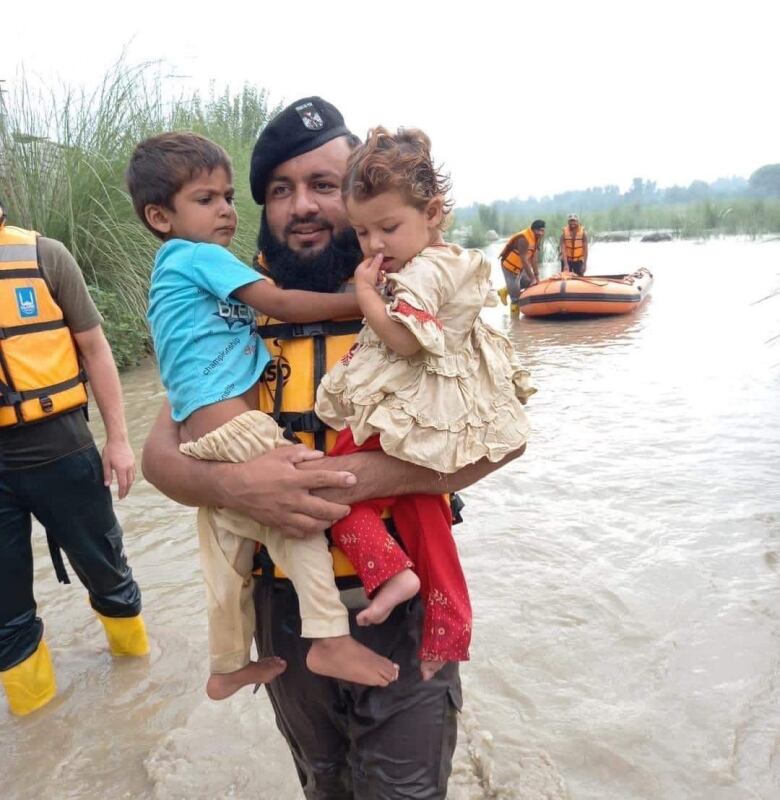 a man carrying two children.