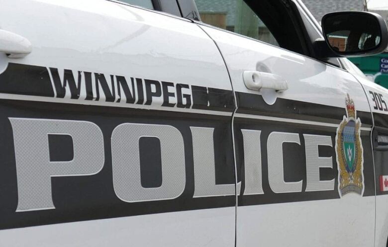 Winnipeg police black and white car parked on street.