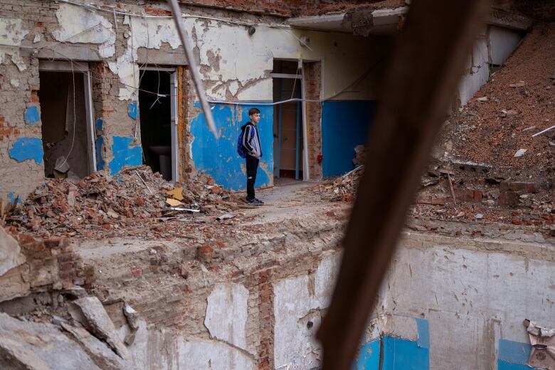 A child stands in a ruined building.