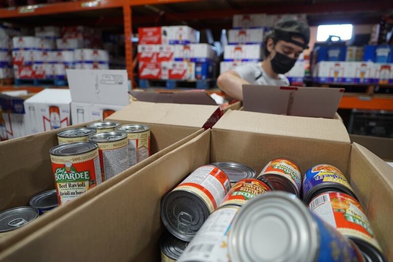 A volunteer at the London Food Bank loads up a shopping cart full of hampers for families in need. The charity has seen a record-setting summer in terms of demand and with inflation pinching family budgets all over the city, donations will likely suffer too. 