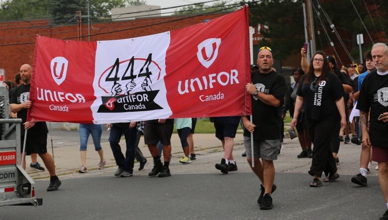 Union workers wearing black t-shirts marching in a parade