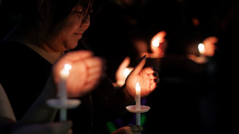 woman holding a candle at a vigil