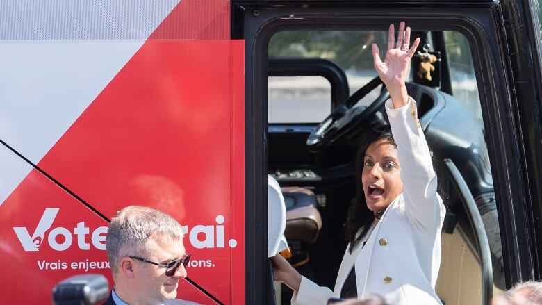 A woman waves her hand.