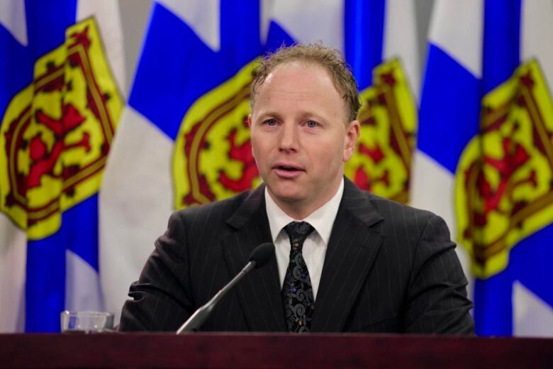 Allan MacMaster in front of Nova Scotia flags in One Government place, Halifax, N.S.