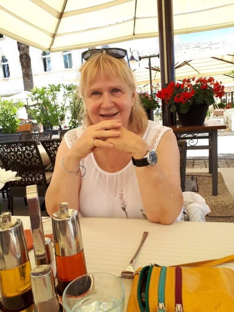 Lorrie Williams smiles as she sits at a table in a restaurant.