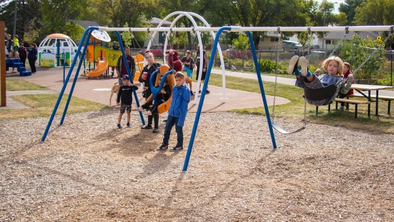 Children play on a swing set at a playground