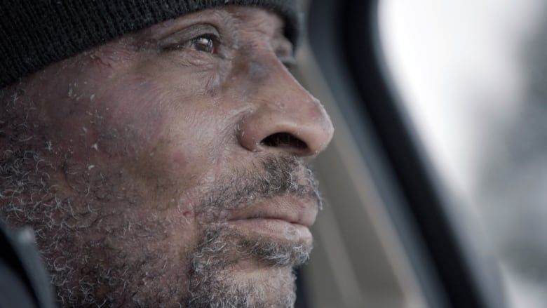 Dewayne Lee Johnson, a Black man in his 40s, stares out the front window of his car.