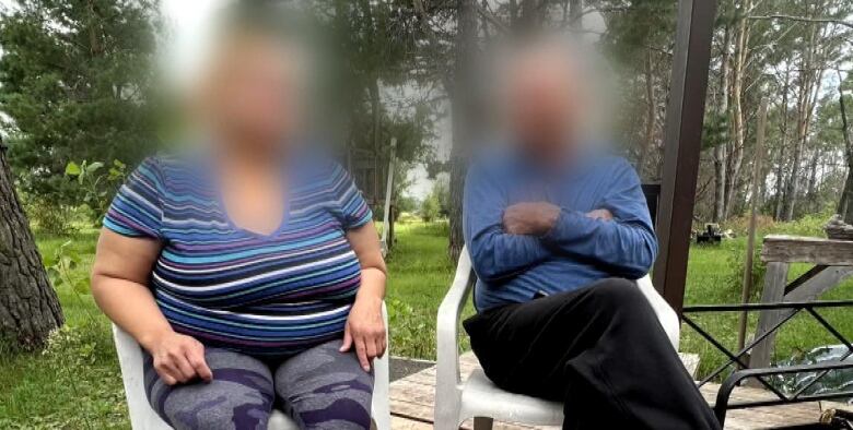 A woman and a man, their faces digitally blurred, are shown sitting on chairs on a deck outside a home.