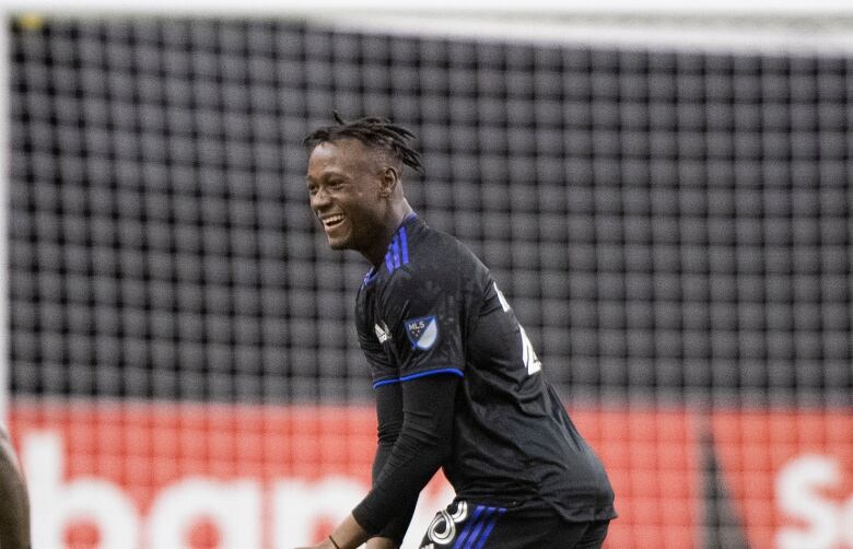 A young man grins at his soccer teammates.