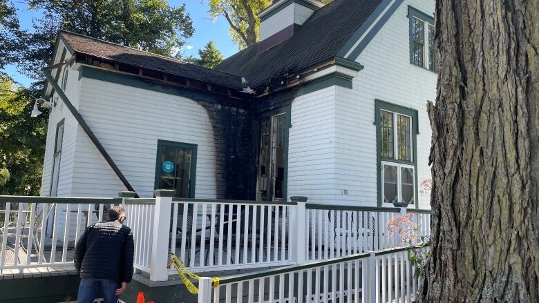 A portion of a wooden building is blackened by fire.