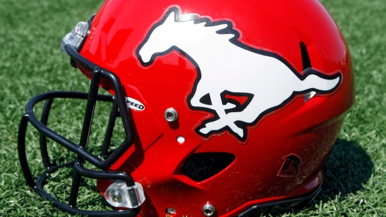 A football helmet rests on the turf. 