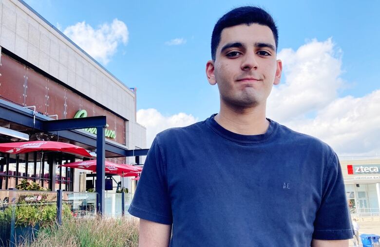 Portrait of man in front of storefronts.