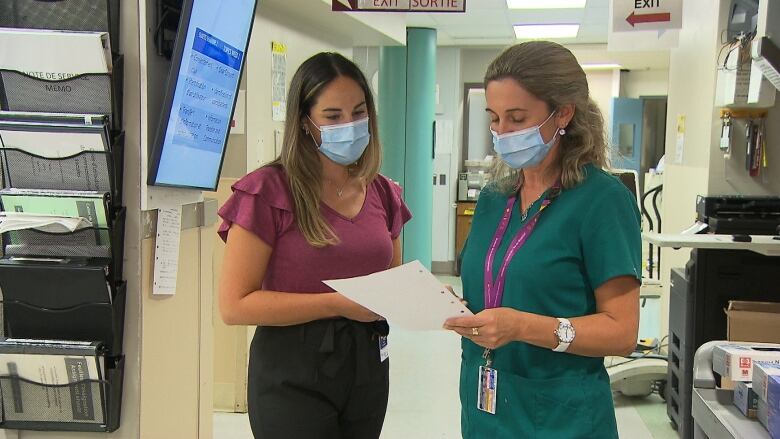 Two nurses stand in a hospital