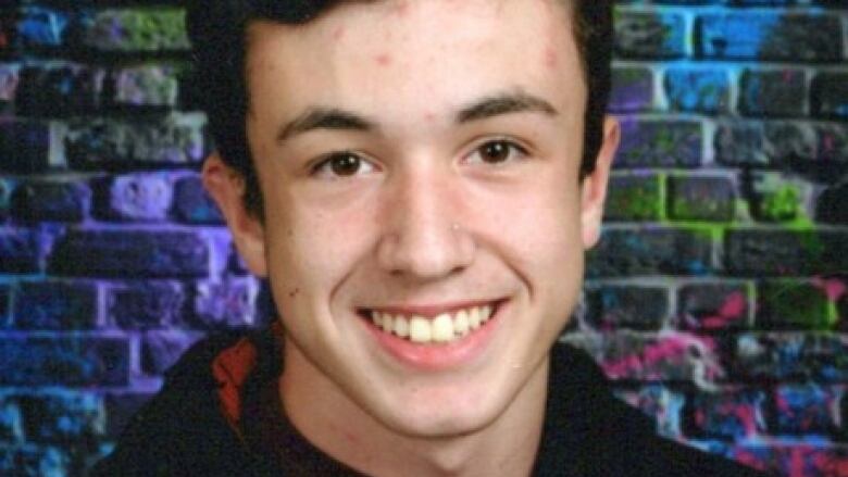 A young man smiling in a posed photo.