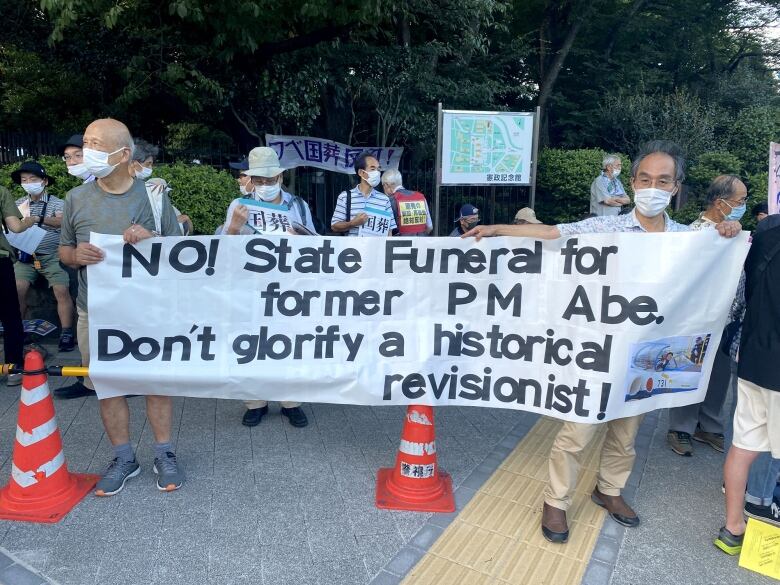 People protest with a large banner.