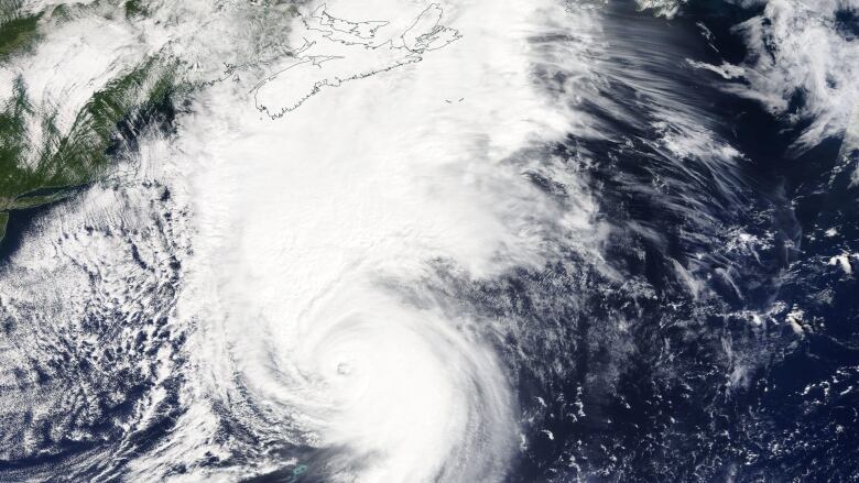 A satellite image shows a white circle approaching Nova Scotia. Sable Island appears as two little lines in the ocean.