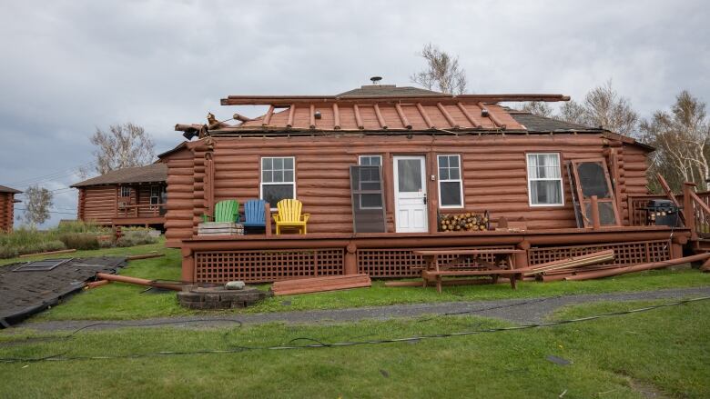 A wood cabin with roof damage