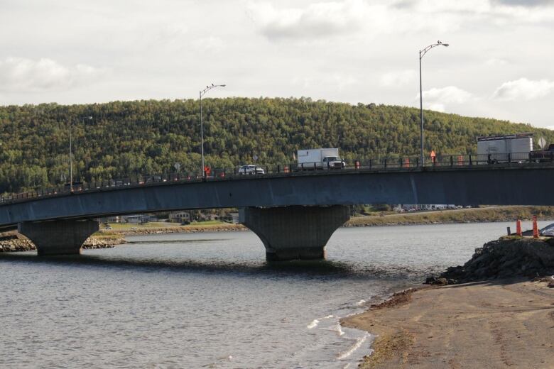 Cars and trucks drive over a bridge.