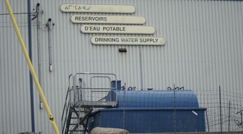 Picture of a blue water tank and signs that say 'Drinking water supply'.