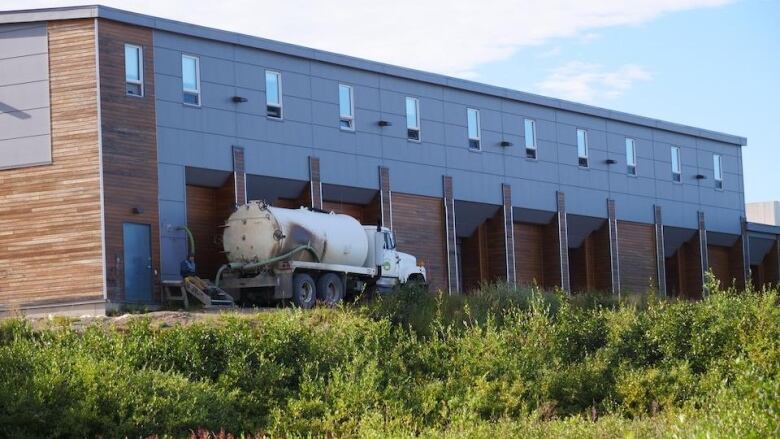 Picture of a tanker truck in front of a building.