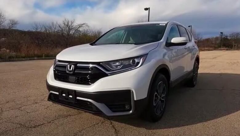 A white Honda SUV in an empty parking lot. 