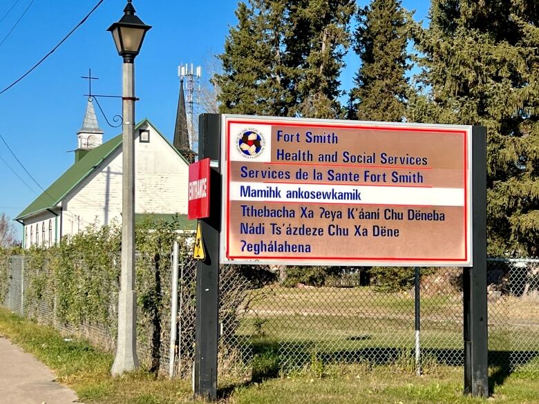 Sign on a street, clapboard church in the background.