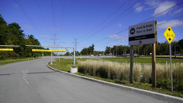 A sign reads Park & Ride, Chapel Hill. An empty cement lot with two cars in the distance.