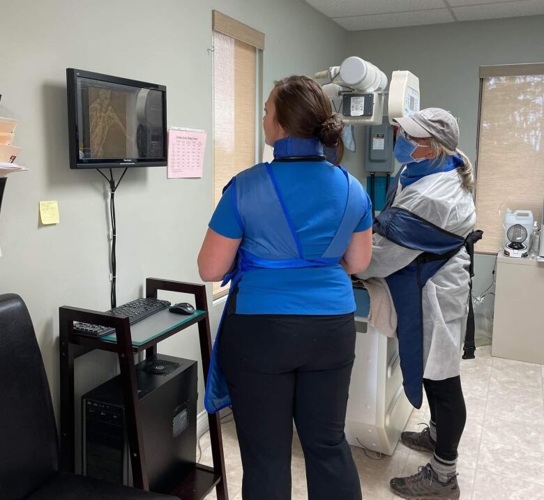 Two nurses are viewing an x-ray.