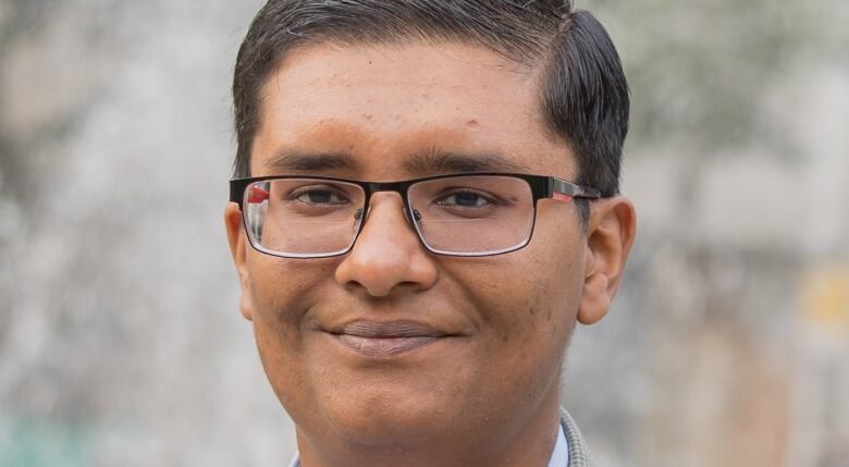 A close up picture of a man in glasses. He has short hair.