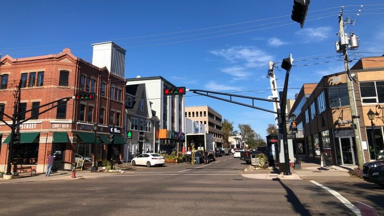 A view of a downtown street corner with restaurants and patios.