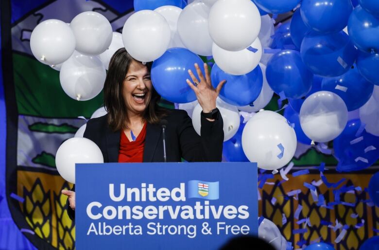 Political woman revels in the midst of balloons.