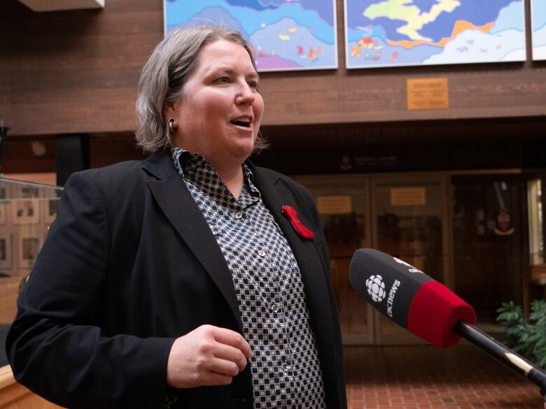 Woman in black jacket at CBC mic.