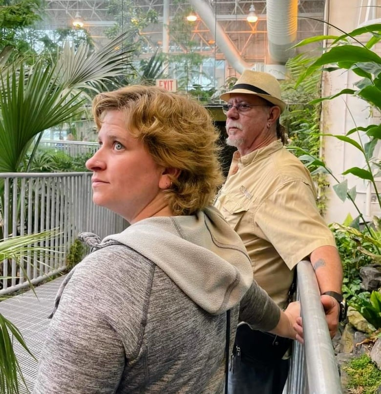 A woman and a man stand next to each other in an indoor jungle of sorts.