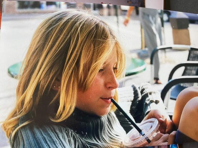 A young girl drinks from a straw