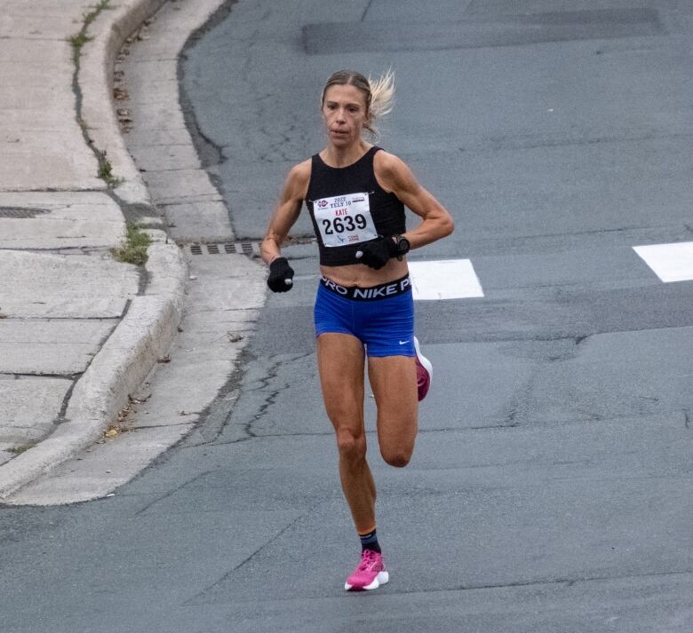 A woman runs down a road.