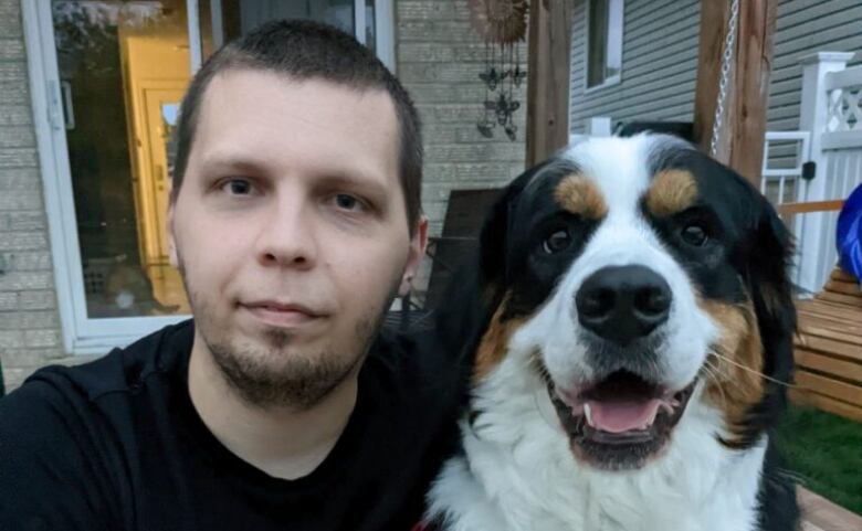 Aleksander poses with his dog. 